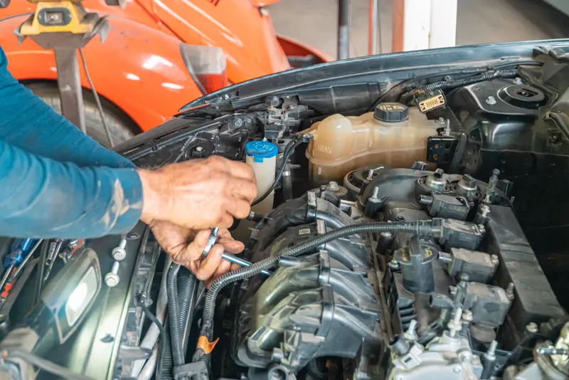 Mecánico ajustando una pieza del motor con una llave